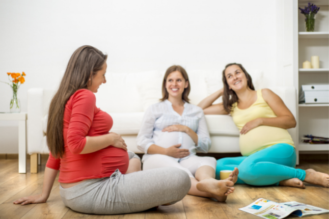 Schwangere Frauen sitzen zusammen